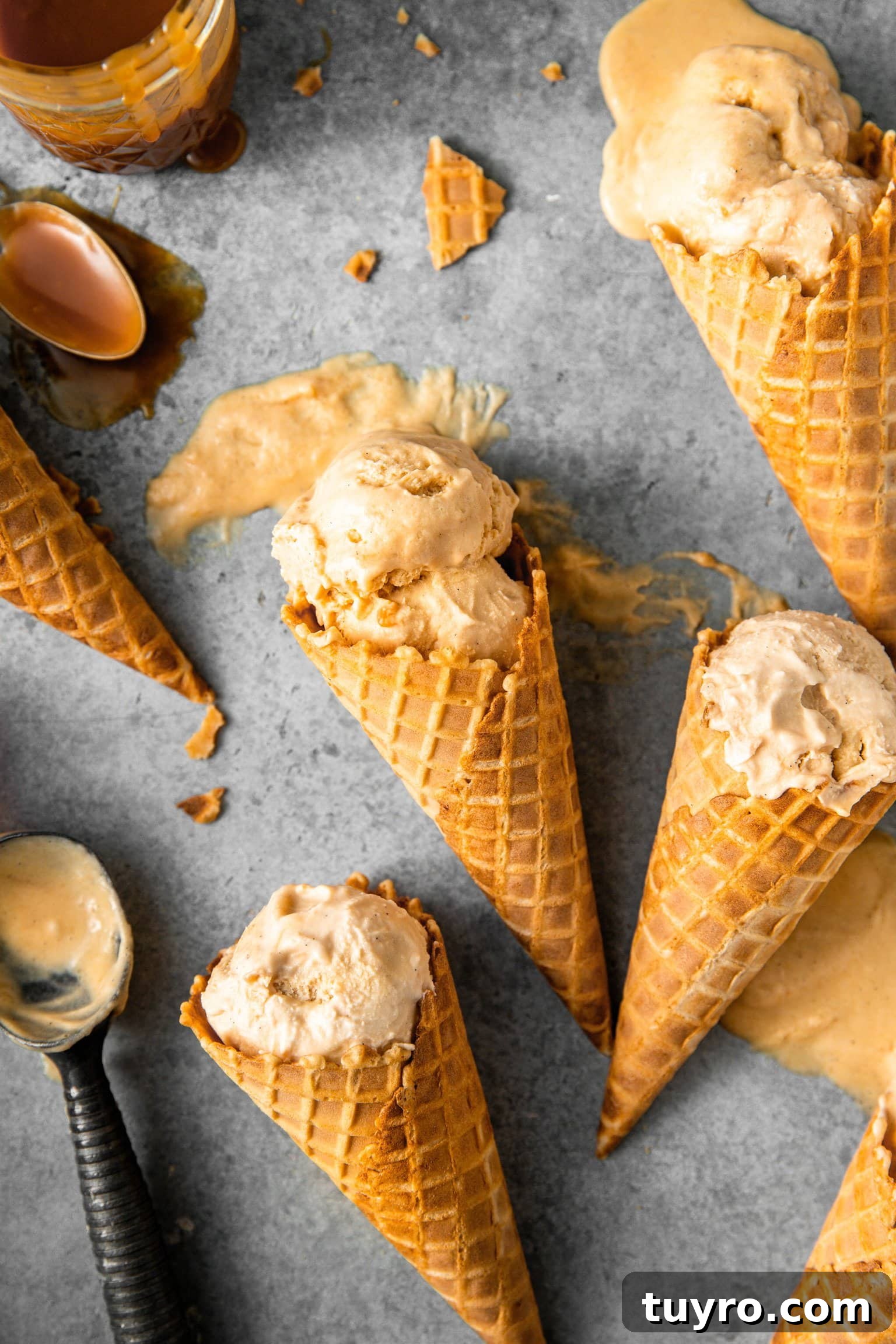 No-Churn Bourbon Salted Caramel Ice Cream Recipe 3 Ice cream cones with scoops of bourbon salted caramel ice cream melting slightly showing creamy texture.