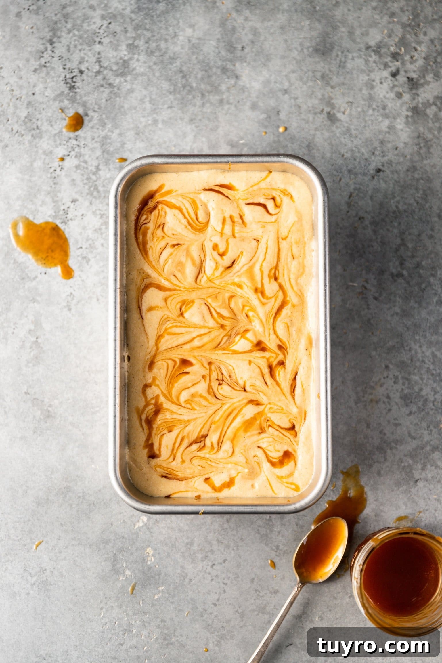 No-Churn Bourbon Salted Caramel Ice Cream Recipe 6 No Churn Bourbon Salted Caramel Ice Cream with caramel swirled on top inside of a loaf pan