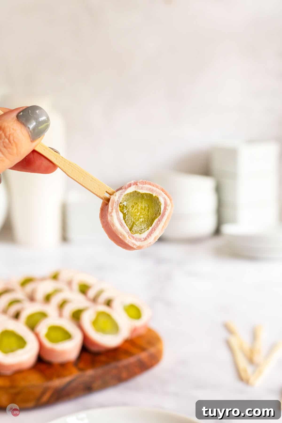 Crunchy Pickle Roll-Ups: Savory Snack Wrap Recipe 9 hand holding a toothpick with ham and pickle