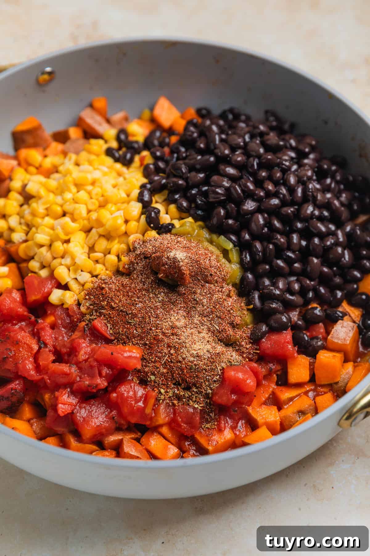Black beans, corn, tomatoes and seasoning added to skillet with cooked sweet potatoes.