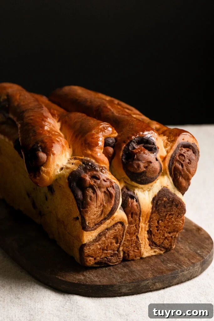 Leopard Milk Bread Recipe: Marbled Hokkaido-Style Loaf 14 Baked loaf of leopard bread on a wooden cutting board.