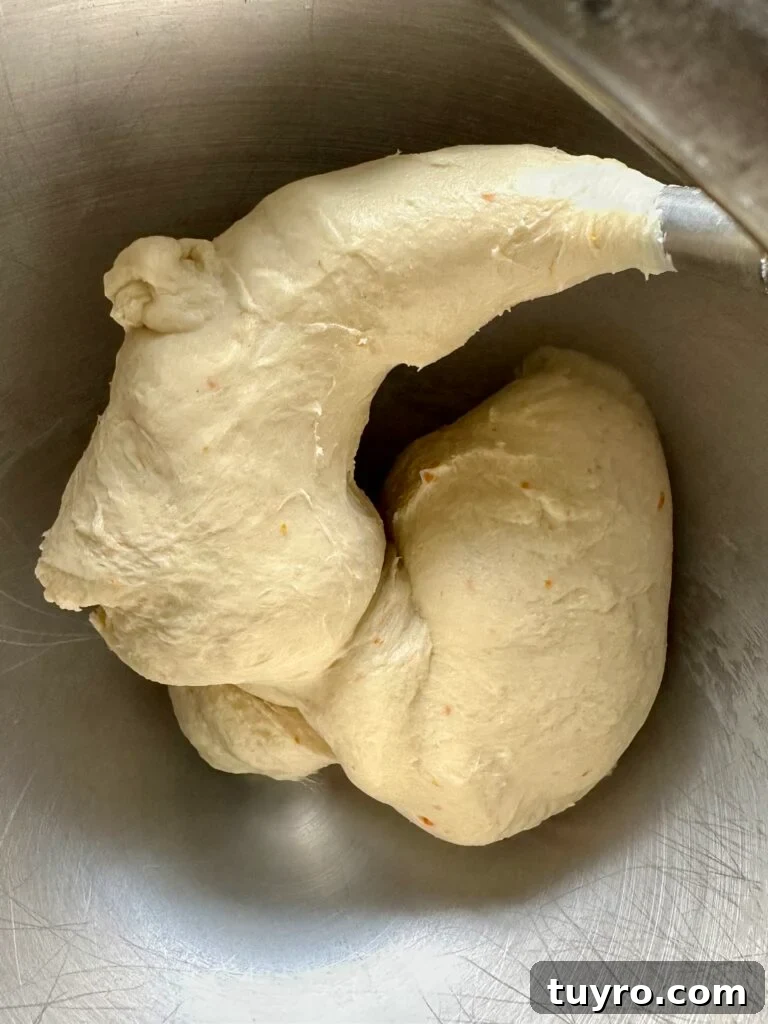 Leopard Milk Bread Recipe: Marbled Hokkaido-Style Loaf 7 Smooth bread dough on a mixing hook inside a bowl.