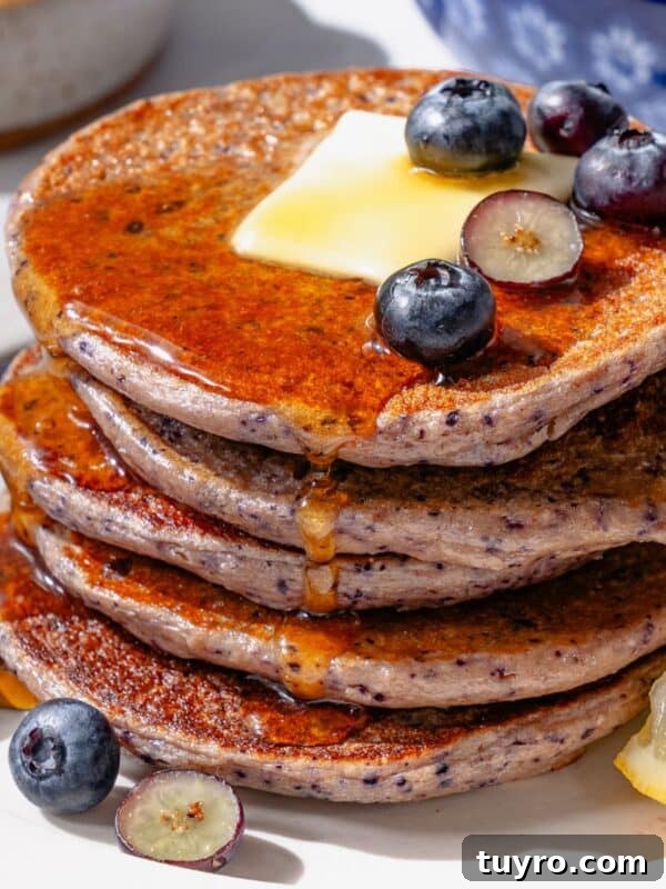 Protein Pancakes on a white plate with blueberries and cottage cheese.