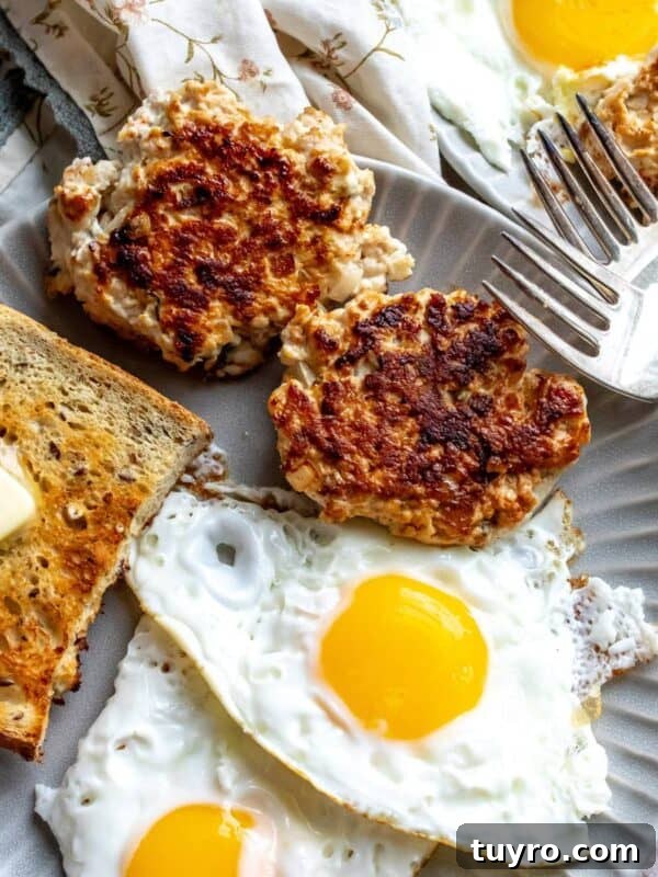 An image of chicken apple sausage with eggs and bread on a plate.