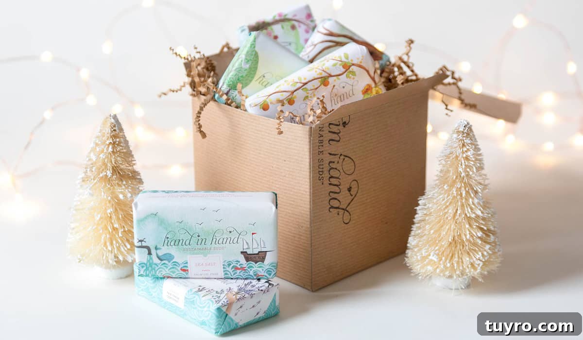 Image shows a gift box from Hand in Hand on a white surface. Handmade soaps sit in front of the box, along with two small tree ornaments