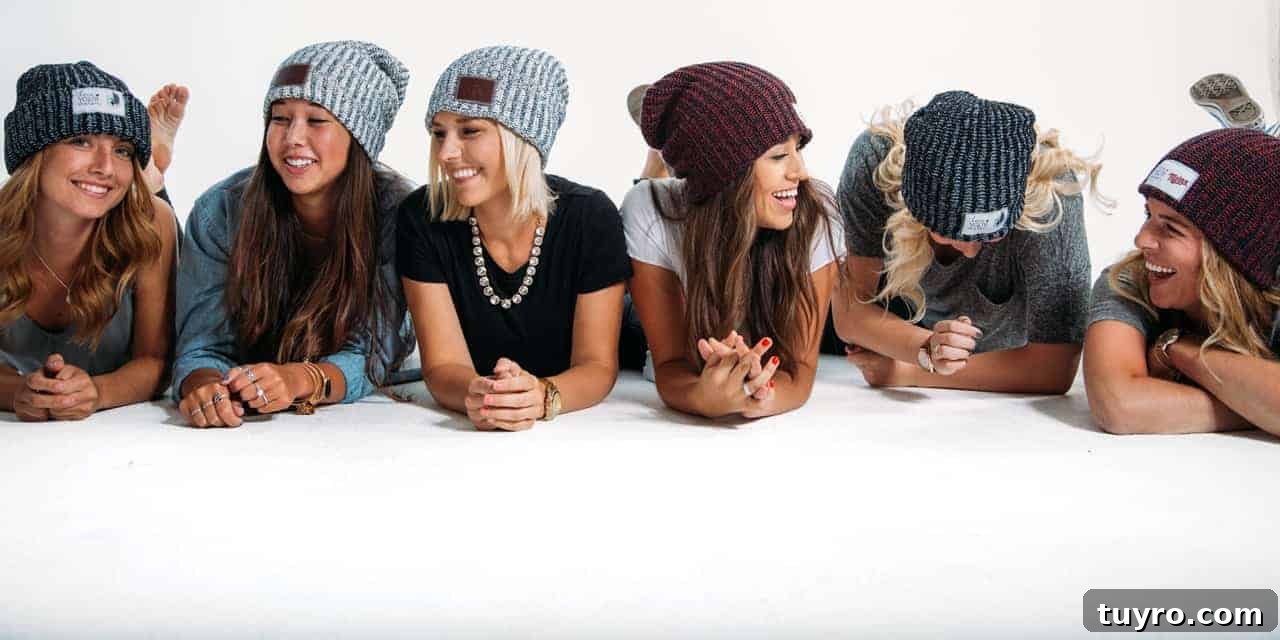Photo shows half a dozen young women laying on their stomachs propped up on their elbows, all wearing a knit Love Your Melon hat.
