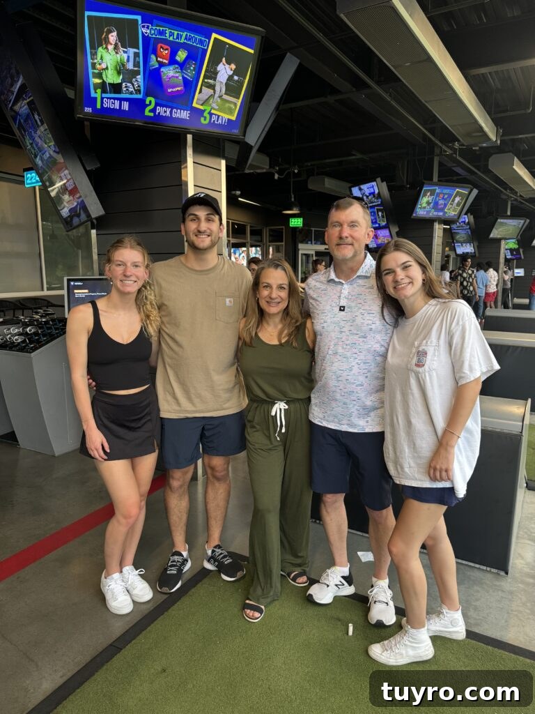 30+ Activities to Connect with Your Young Adult Children 17 Family posing together at Top Golf, enjoying a casual game night of golf and fun with young adult kids.