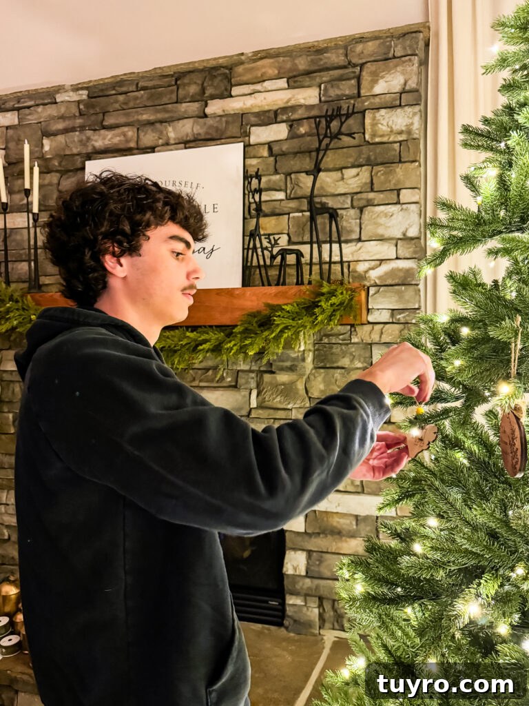 30+ Activities to Connect with Your Young Adult Children 8 Teen decorating the family Christmas tree with ornaments, continuing holiday traditions at home.