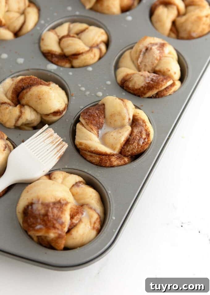 unbaked cinnamon roll muffin dough brushed with milk