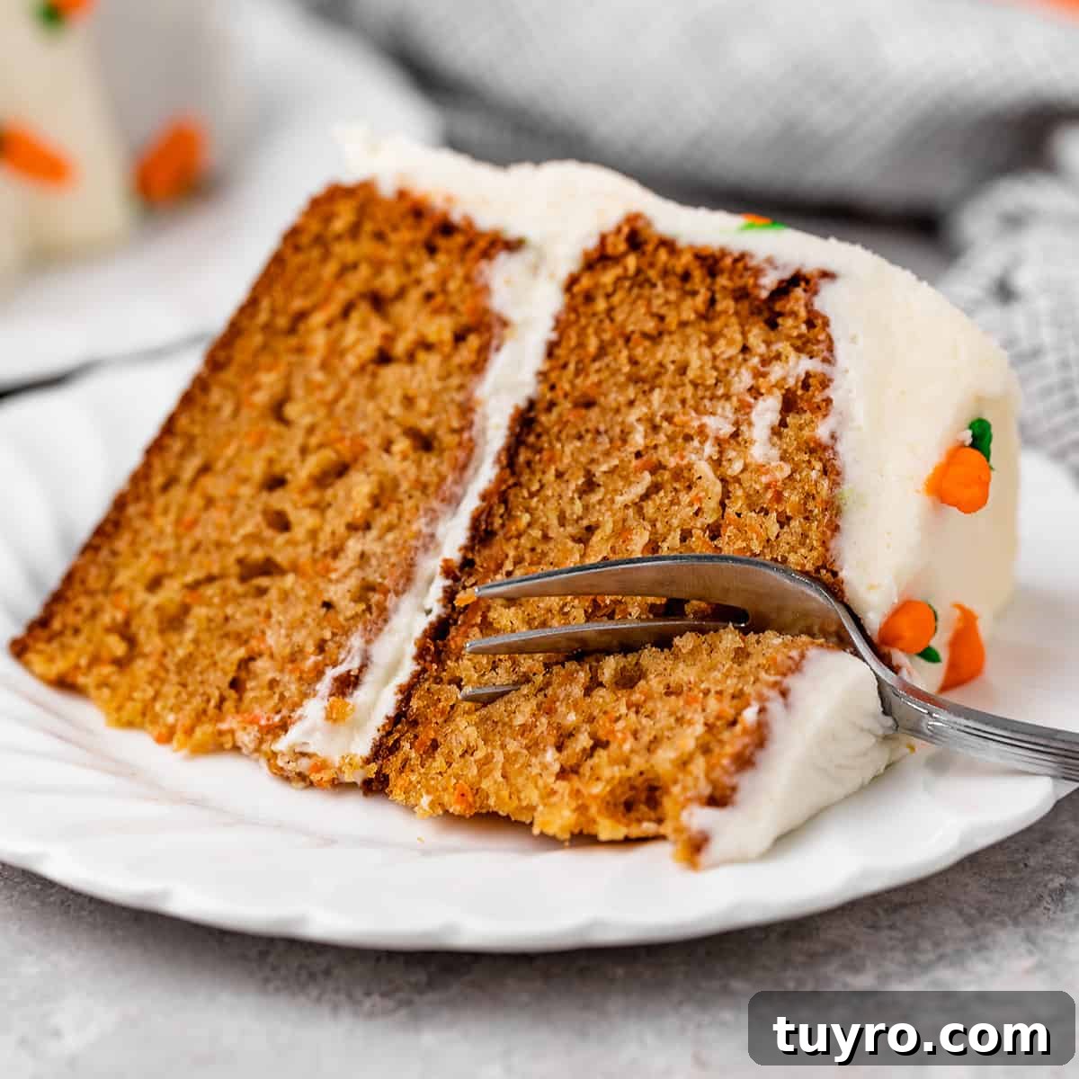 Moist Carrot Cake Recipe with Cream Cheese Frosting 17 a fork taking a bite out of a slice of carrot cake