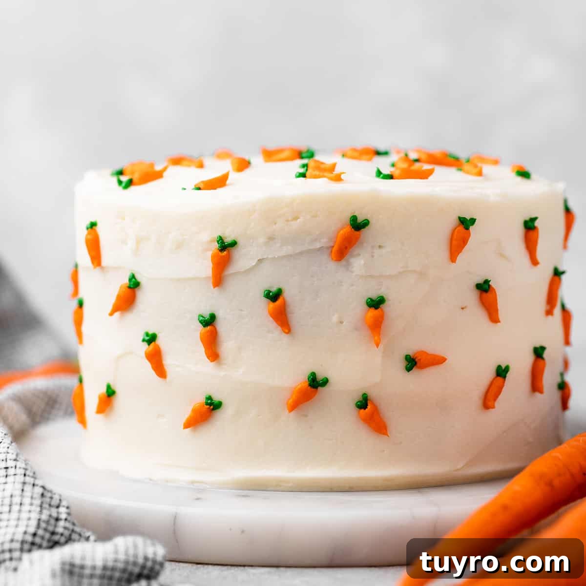 Moist Carrot Cake Recipe with Cream Cheese Frosting 3 a whole carrot cake with cream cheese frosting and tiny frosting carrots all around it