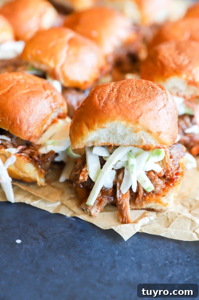 BBQ Pulled Pork Sliders with Crisp Apple Coleslaw 11 Photo of sliders on parchment paper with coleslaw