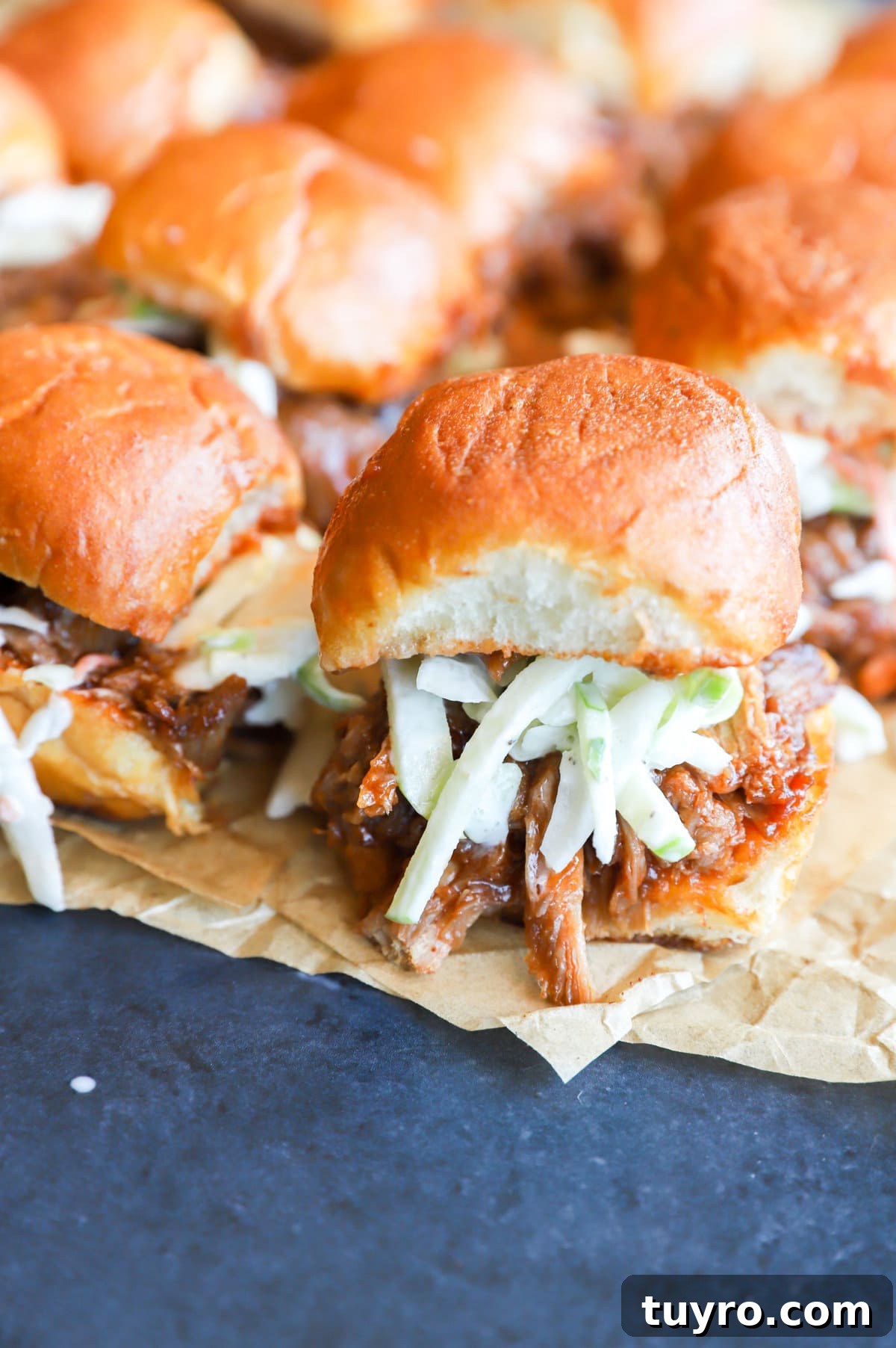 BBQ Pulled Pork Sliders with Crisp Apple Coleslaw 12 Photo of sliders on parchment paper with coleslaw