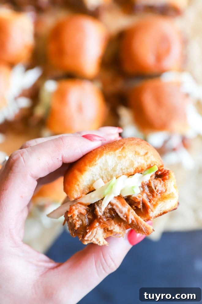 BBQ Pulled Pork Sliders with Crisp Apple Coleslaw 4 Hand holding sandwich with coleslaw picture