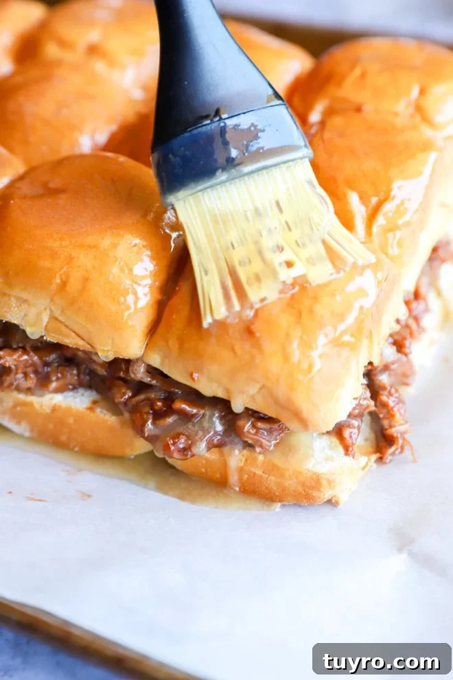 BBQ Pulled Pork Sliders with Crisp Apple Coleslaw 9 Brushing pulled pork sliders with butter image