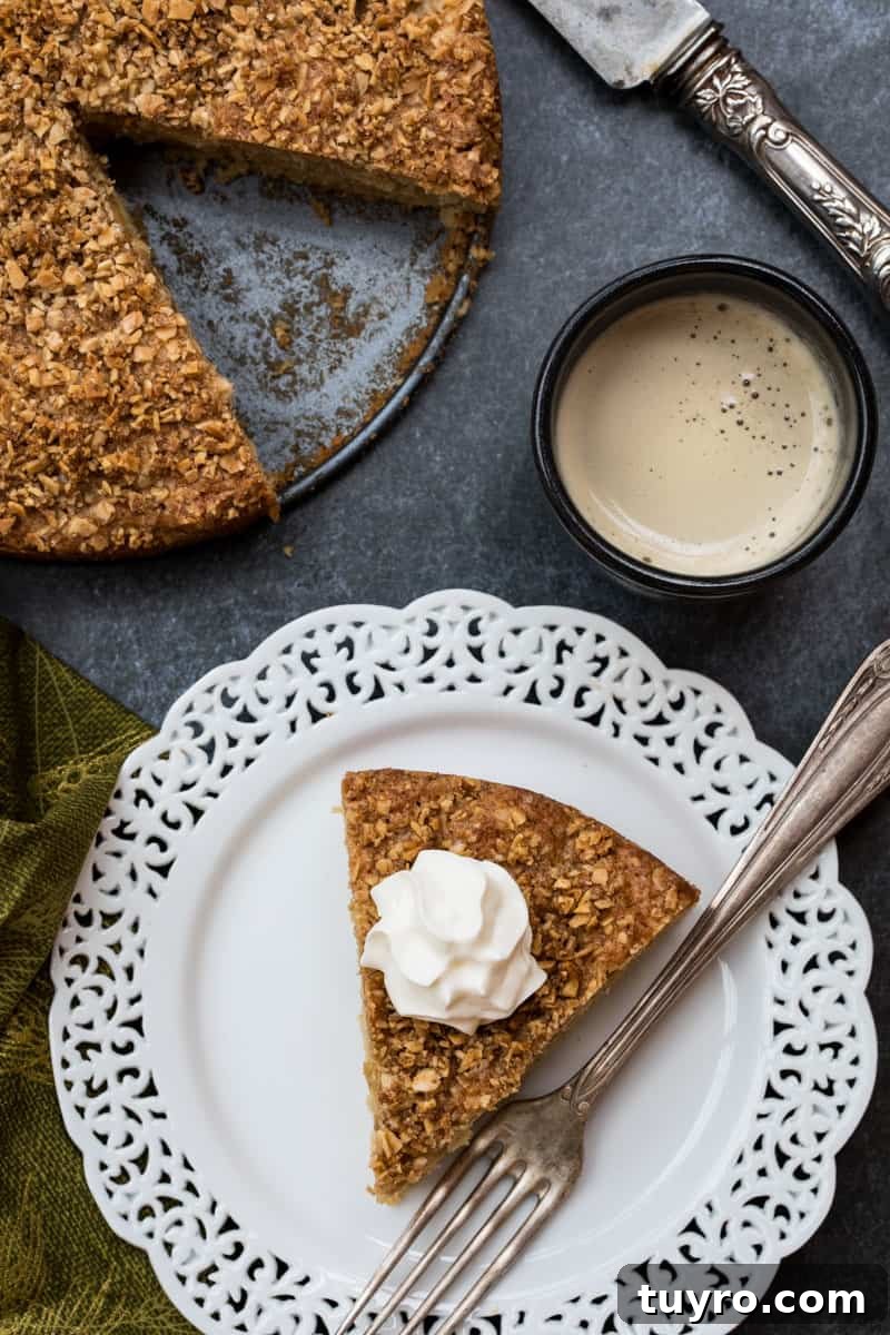 Moist Apple Almond Cake Recipe with Cinnamon 2 plate with slice of apple almond cake topped with whipped cream next to full cake and cup of coffee
