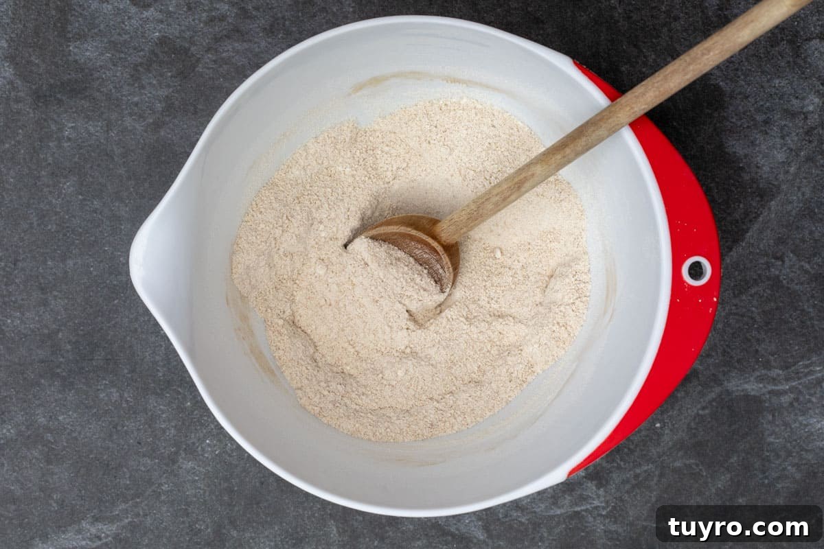 Moist Apple Almond Cake Recipe with Cinnamon 6 dry ingredients in mixing bowl with spoon