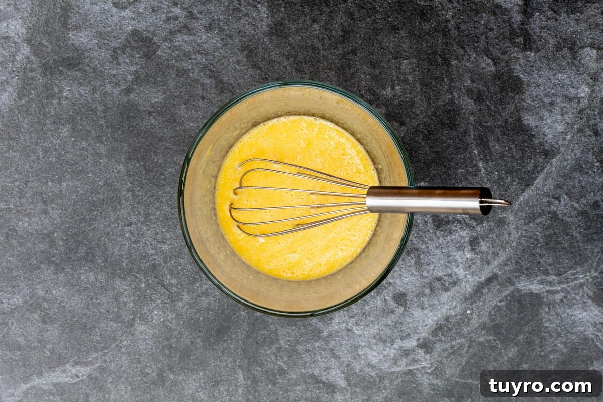 Moist Apple Almond Cake Recipe with Cinnamon 7 whisking eggs and vanilla extract