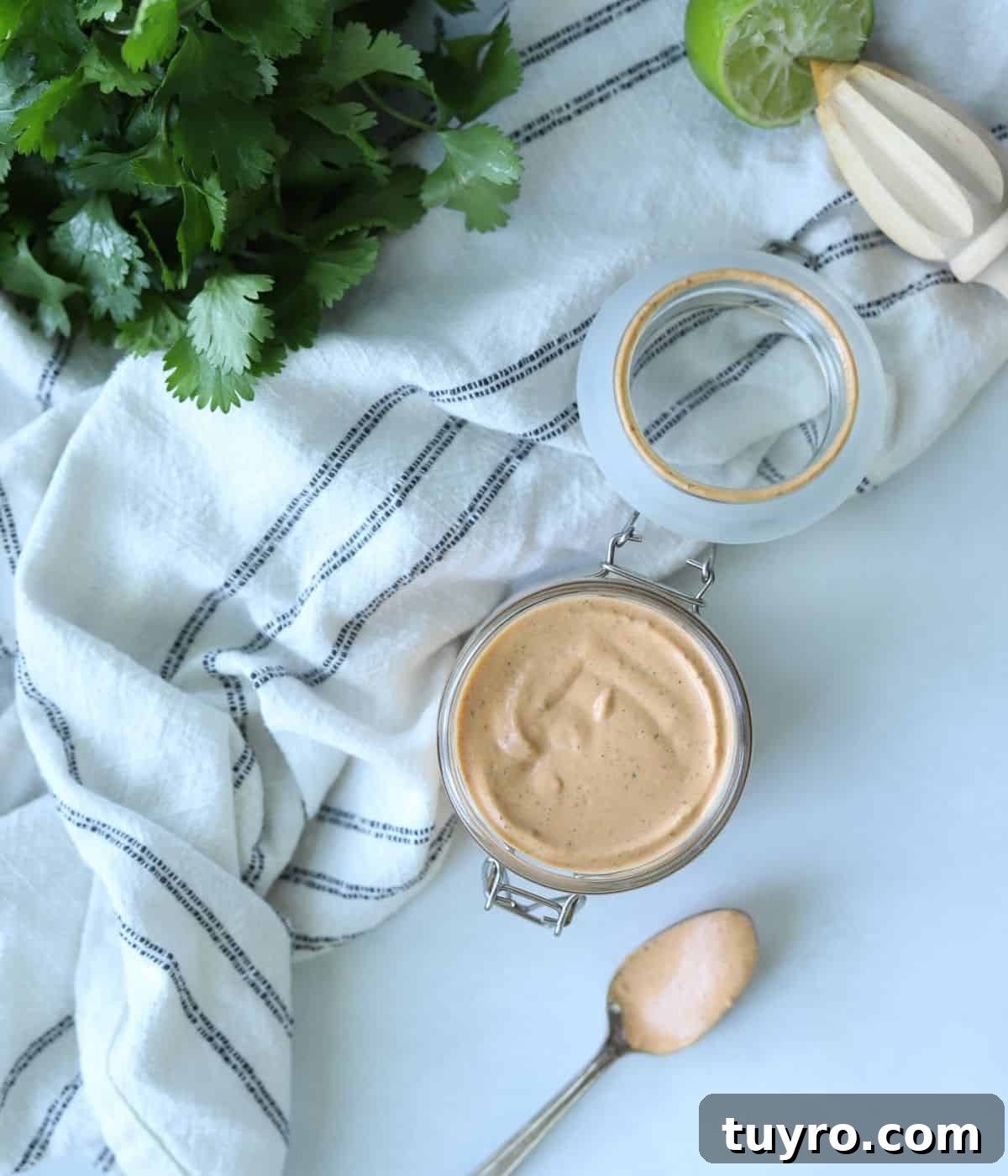 Quick Chipotle Lime Sauce Recipe — Ready in 5 Minutes 5 overhead view of Chipotle mayo in glass container with a bunch of cilantro in background