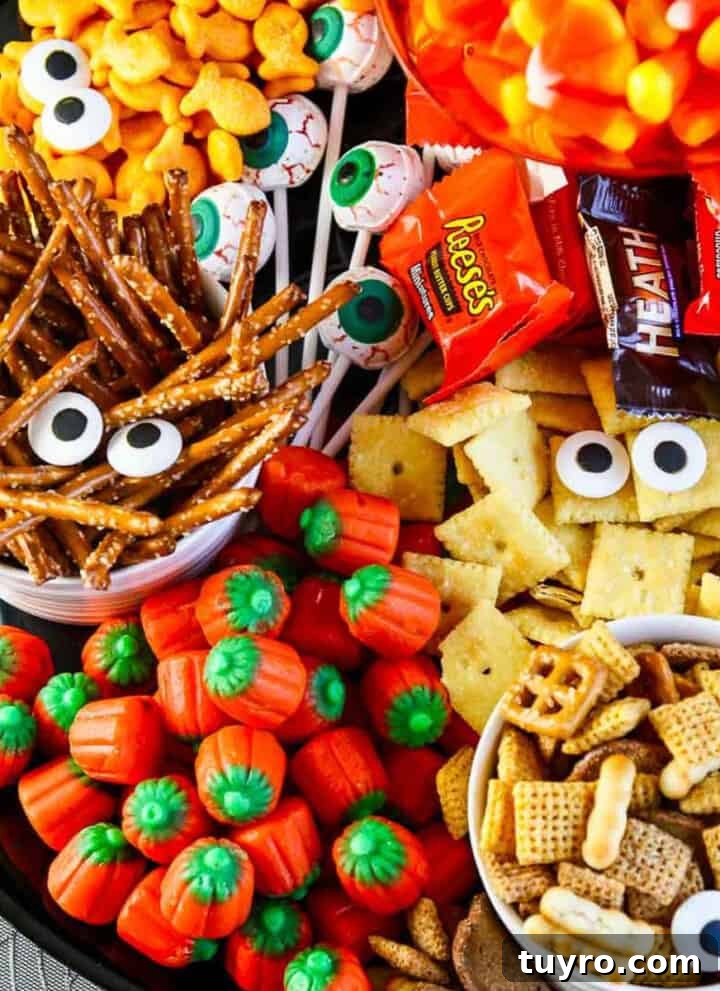 A full platter of Halloween salty snacks and candy decorated with candy eyeballs for an easy last minute Halloween Party Idea.