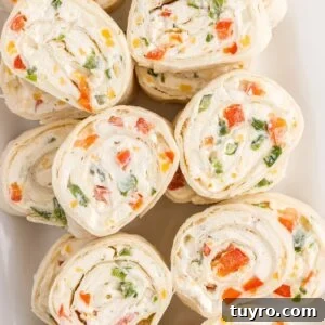 Creamy Ranch Pinwheel Appetizers for Parties and Potlucks 15 Sliced ranch pinwheels on a white plate.