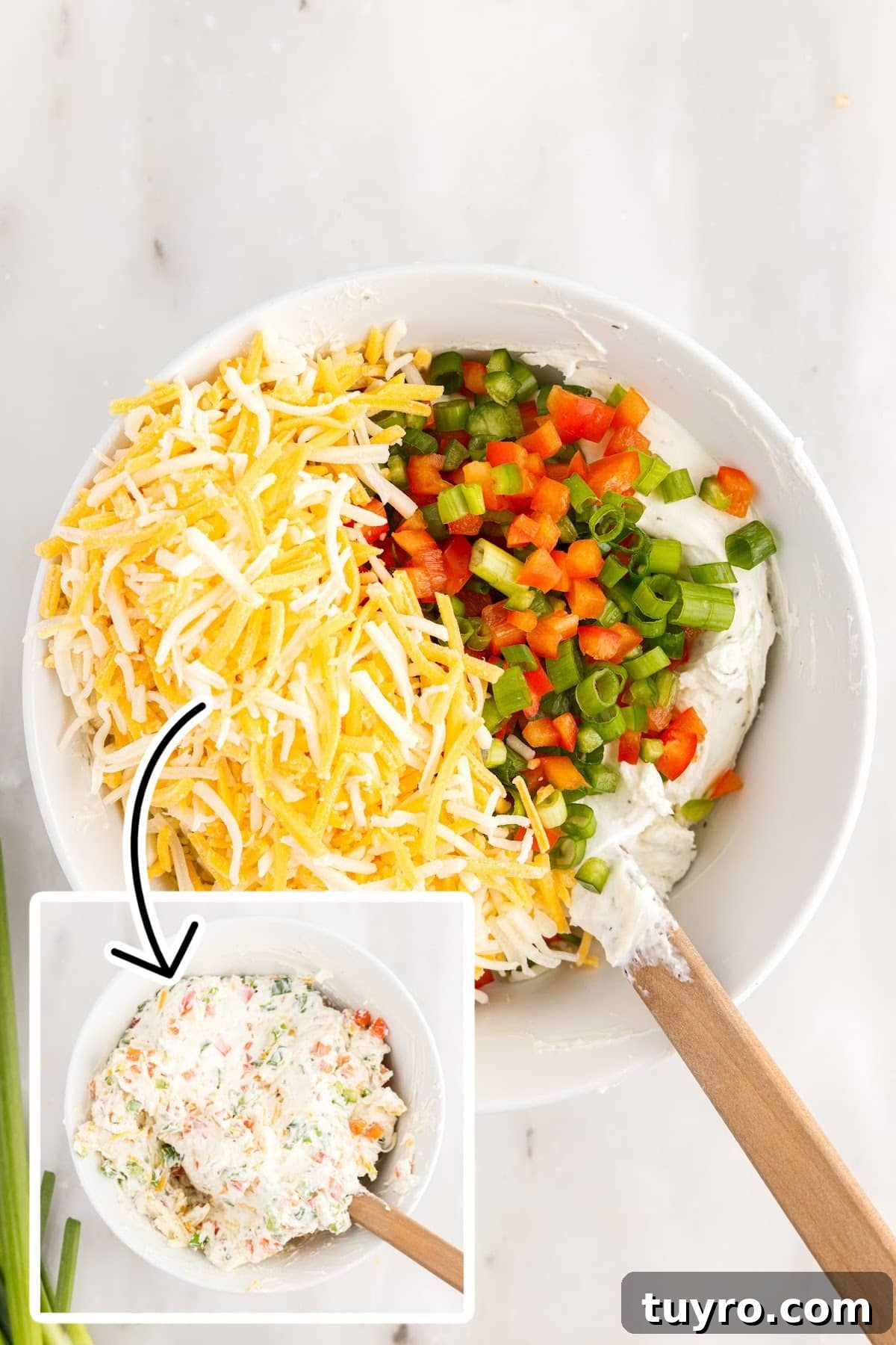 Creamy Ranch Pinwheel Appetizers for Parties and Potlucks 5 Mixing the cream cheese, veggies, and other cheese in a white mixing bowl.