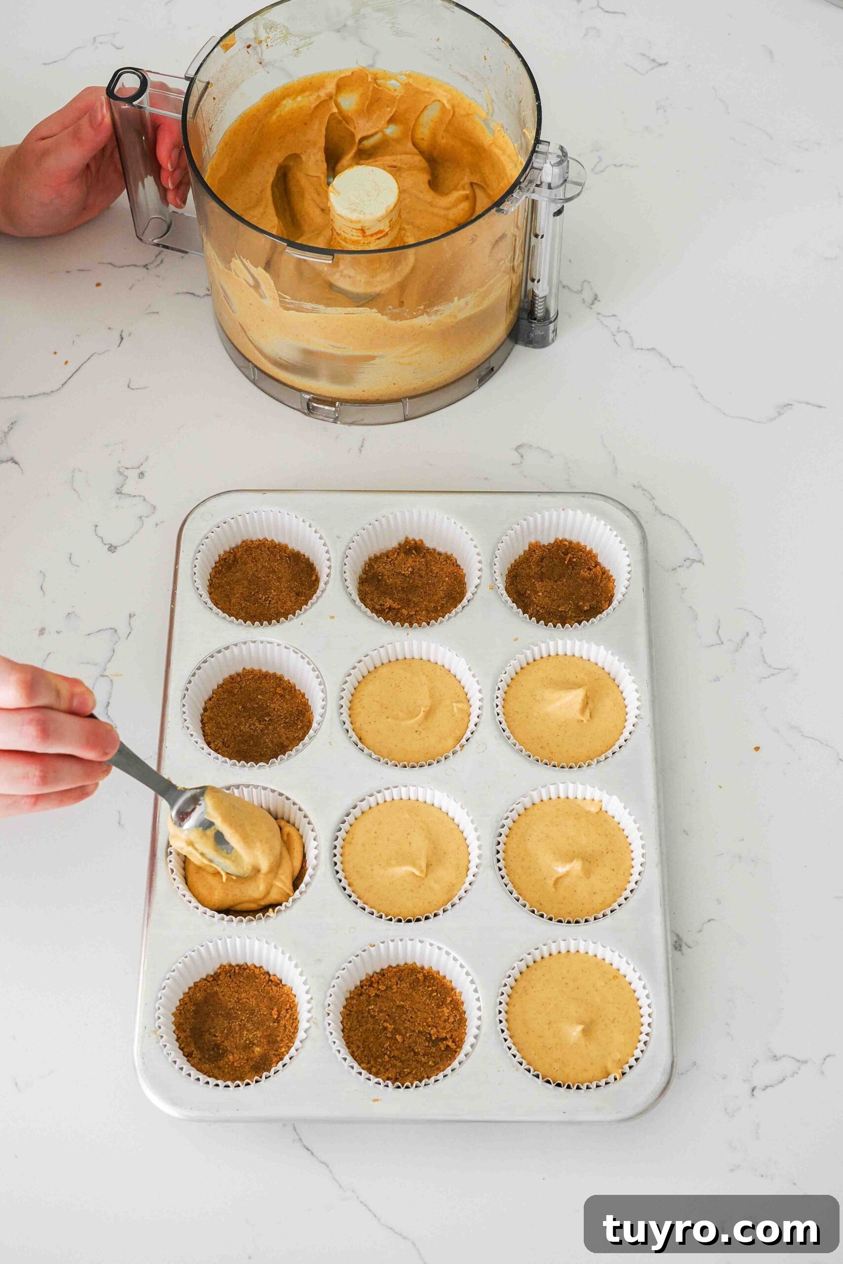 Mini Pumpkin Cheesecake Bites with Spiced Gingersnap Crust 11 Pumpkin cheesecake is scooped into paper muffin liners.
