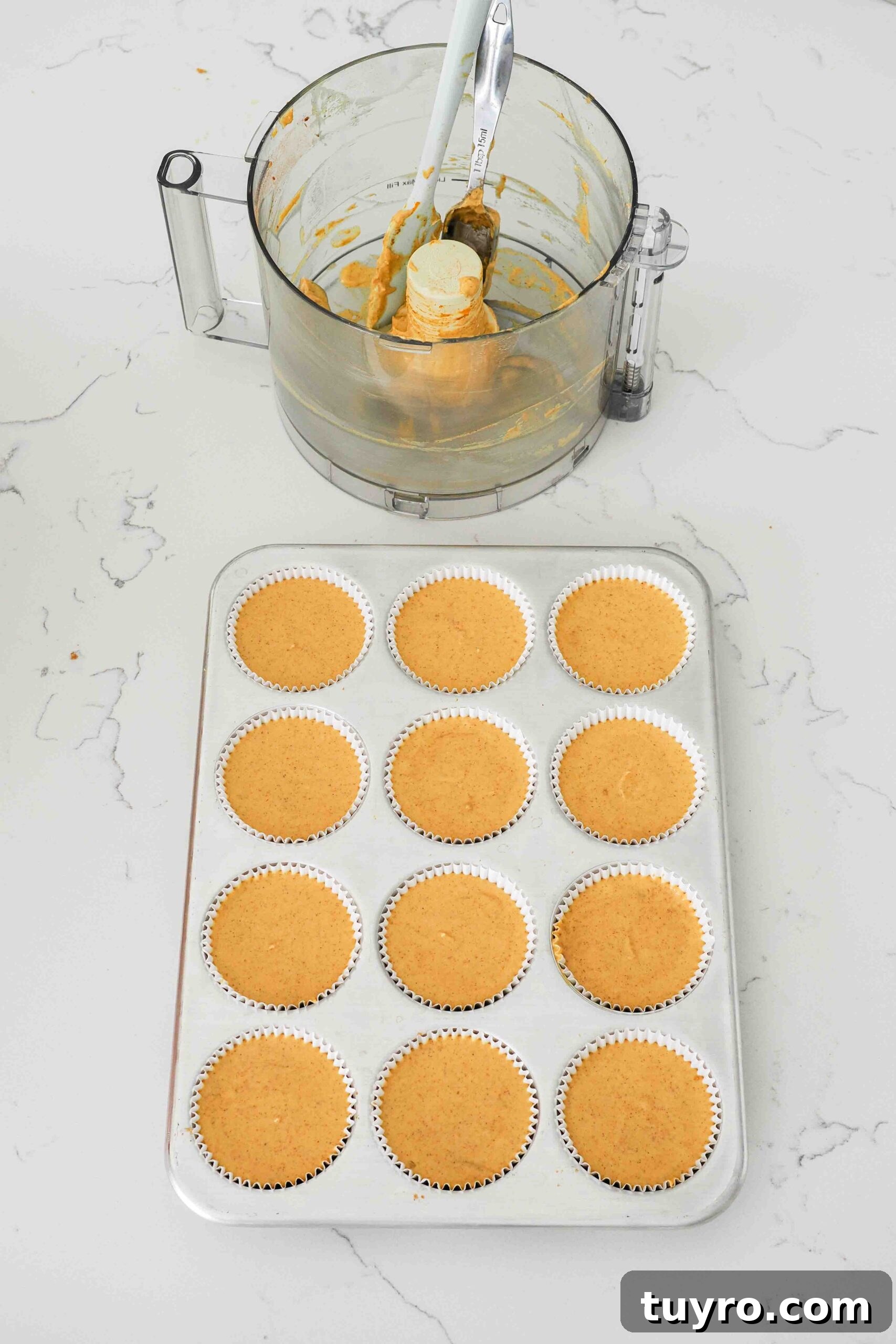 Mini Pumpkin Cheesecake Bites with Spiced Gingersnap Crust 12 Unbaked mini pumpkin cheesecakes in a muffin pan.