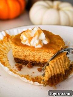Mini Pumpkin Cheesecake Bites with Spiced Gingersnap Crust 17 A fork removes a piece of a mini pumpkin cheesecake on a plate.