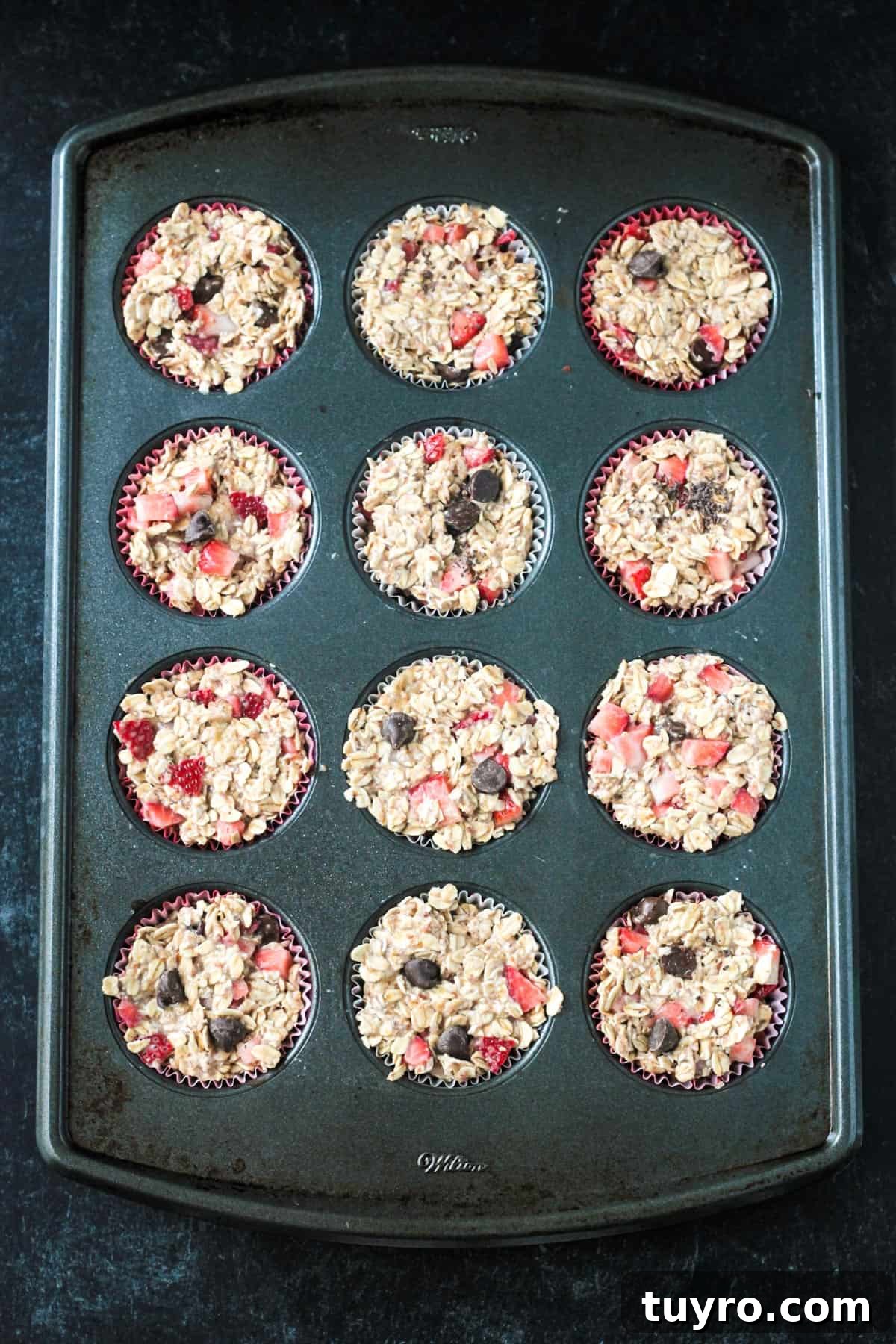Strawberry Baked Oatmeal Muffins Recipe for Moist Breakfast Bites 6 Raw batter in a muffin pan.