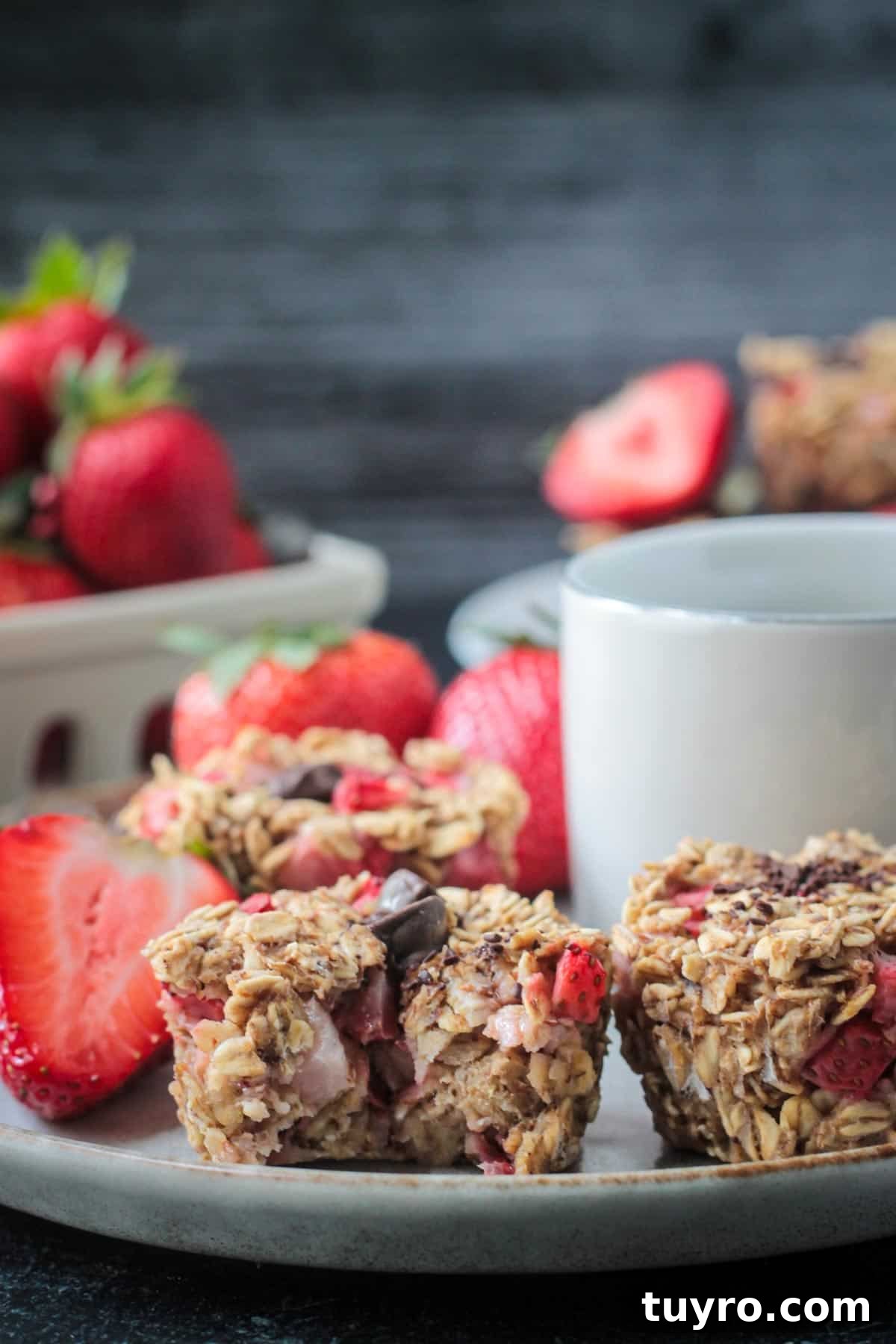Strawberry Baked Oatmeal Muffins Recipe for Moist Breakfast Bites 12 One muffin with a bite taken out of it on a plate.
