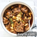Gluten-Free Jamaican Oxtail Stew Recipe for Rich, Authentic Flavor 7 Jamaican Oxtail Stew in a white serving bowl with spoon