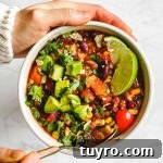holding a bowl of Instant Pot Vegan Chili in a white bowl