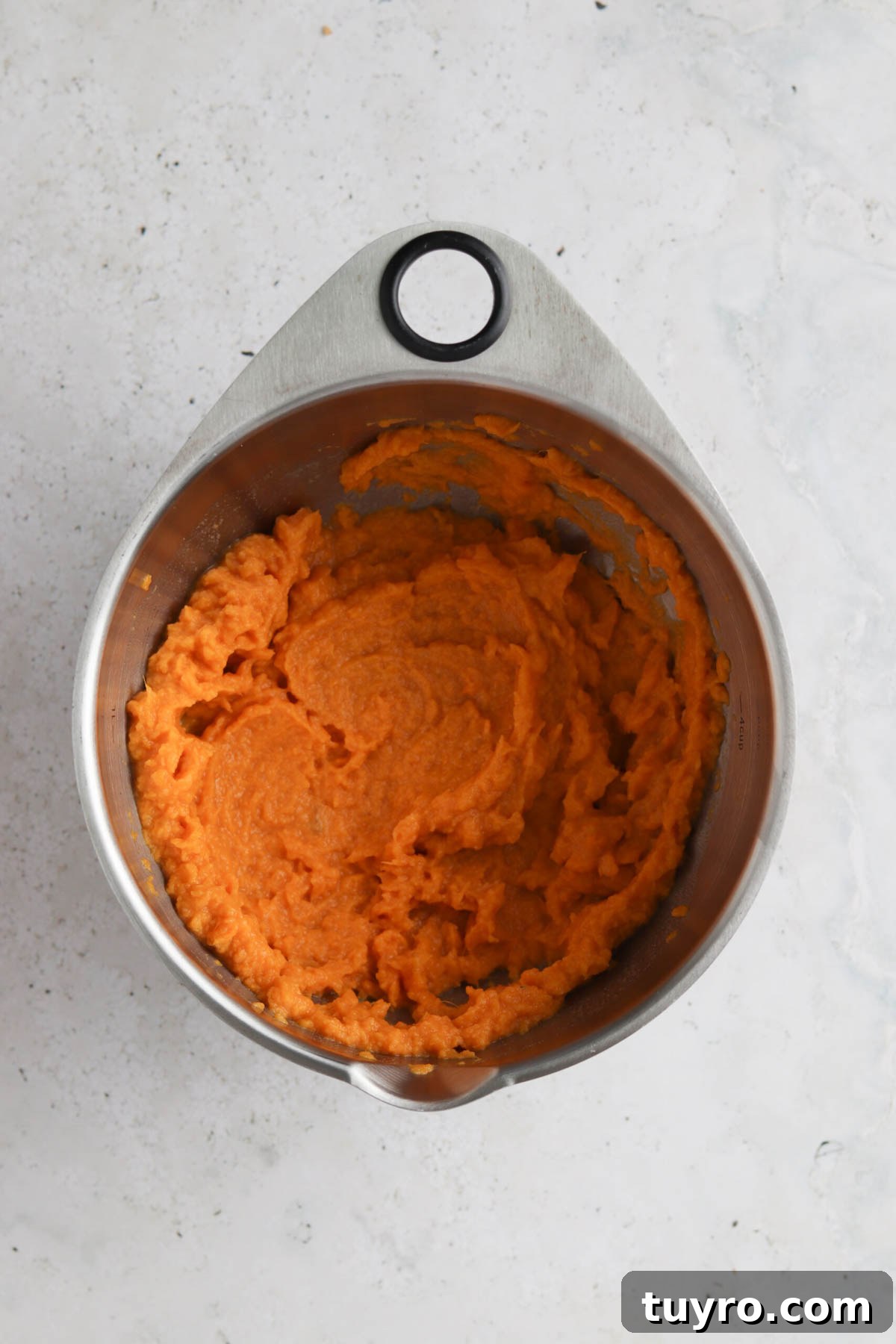 Vegan sweet potato mash in a metal mixing bowl.