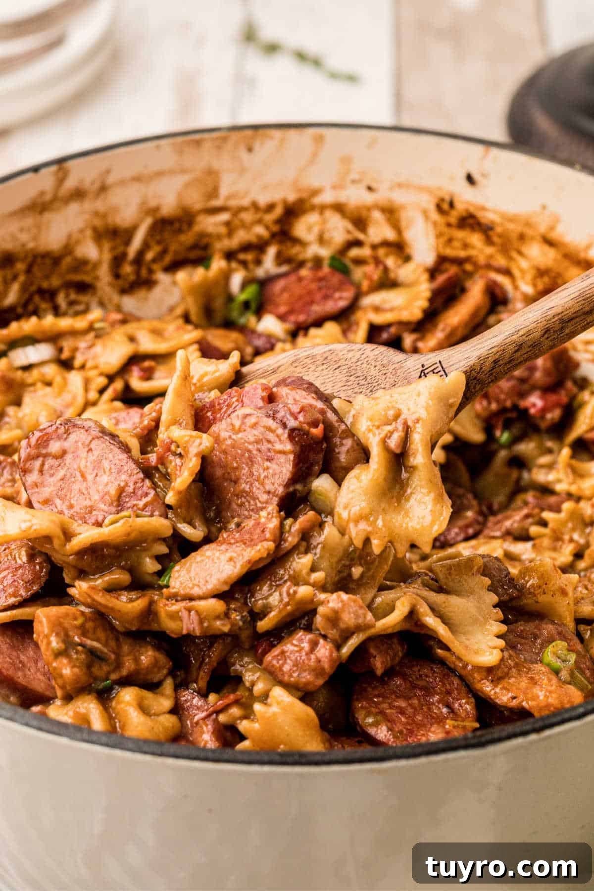 Very close up picture of a spoon digging into a pot of pastalaya.