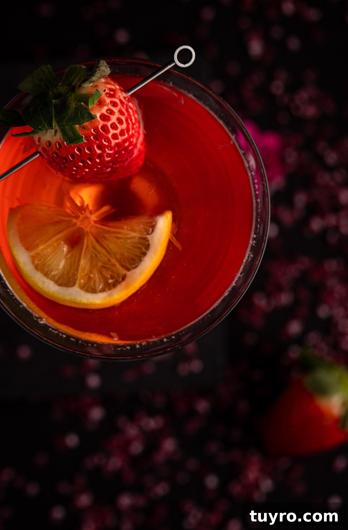 Overhead view of martini garnished with a strawberry and a slice of lemon.