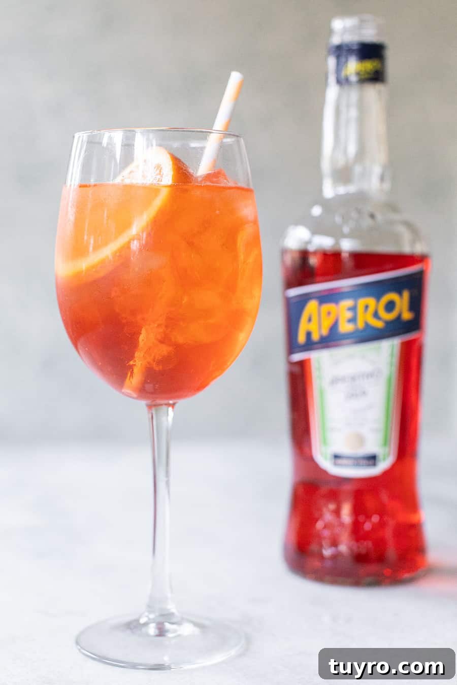 3-Ingredient Aperol Spritz Recipe for Summer Cocktails 6 Close-up of fizzy Aperol Spritz with orange garnish on a summer table.