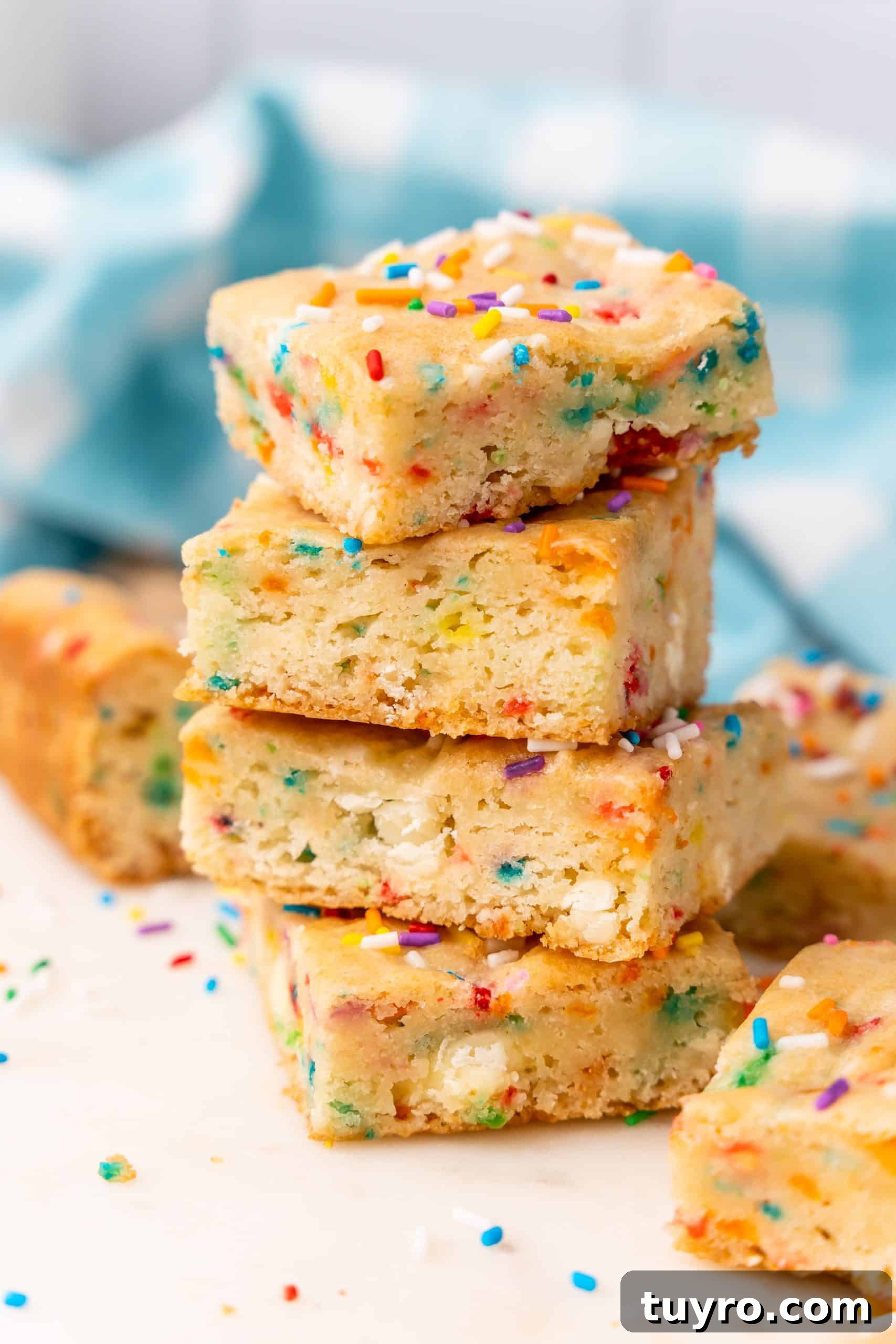 Birthday Cake Blondies Recipe with Sprinkles and Frosting 3 four birthday cake blondies stacked on top of each other