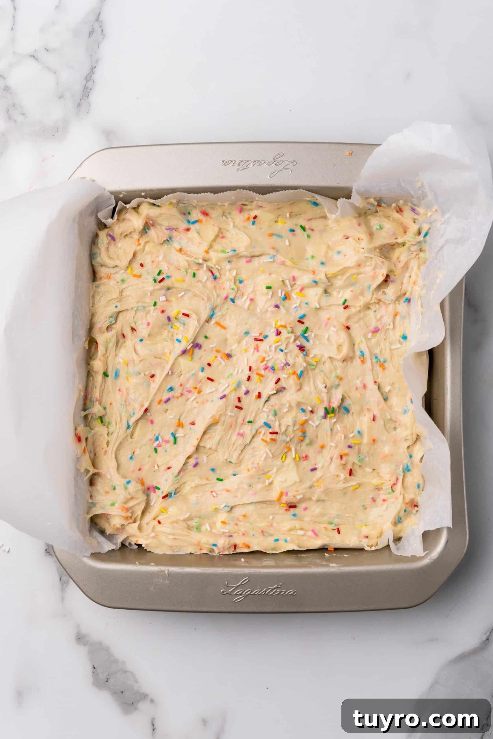 Birthday Cake Blondies Recipe with Sprinkles and Frosting 9 funfetti cake batter mix in a parchment paper lined baking pan