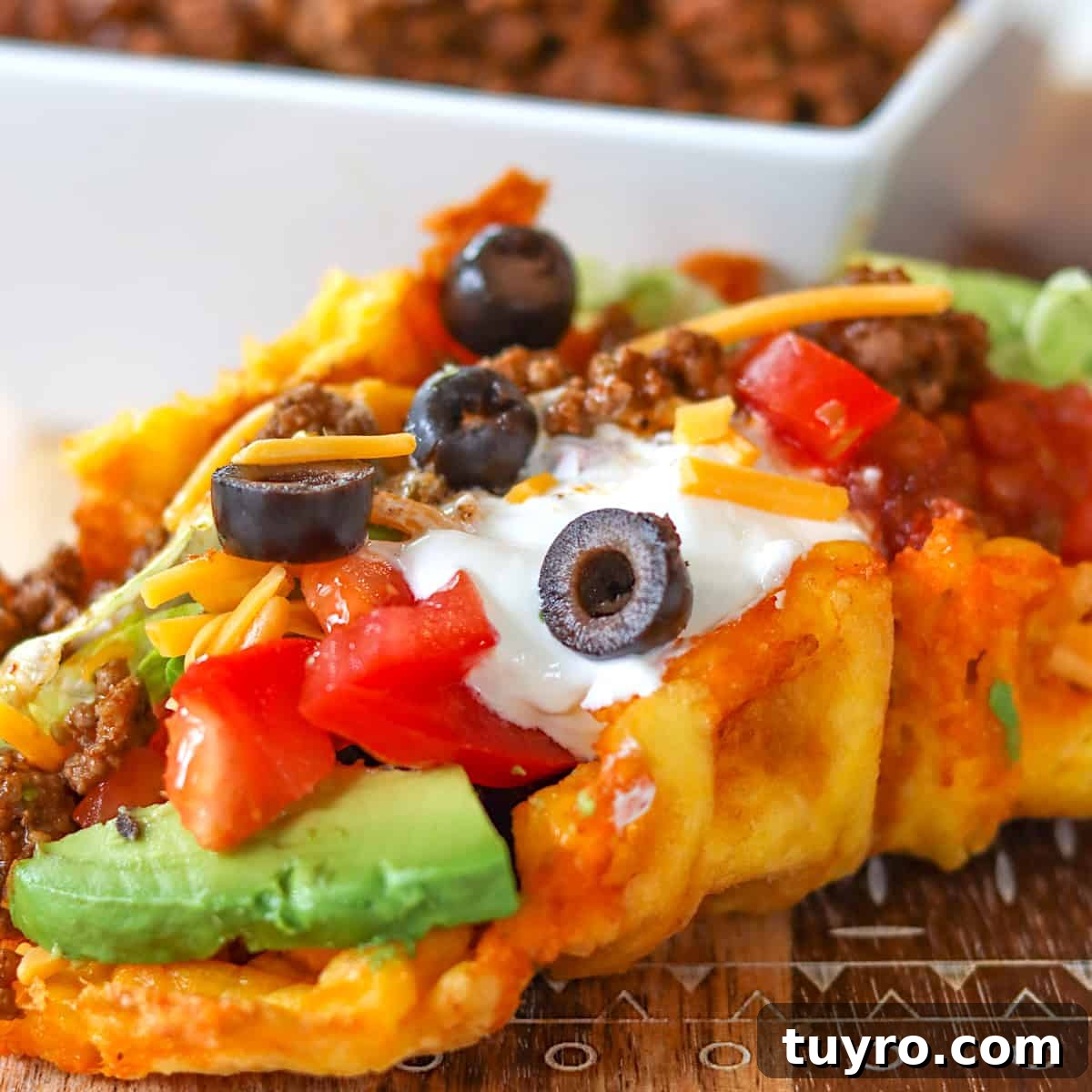 30 Taco Tuesday Ideas for a Craveworthy Dinner 8 A chaffle taco served on a wooden board and garnished with olives, avocado, and cheese.