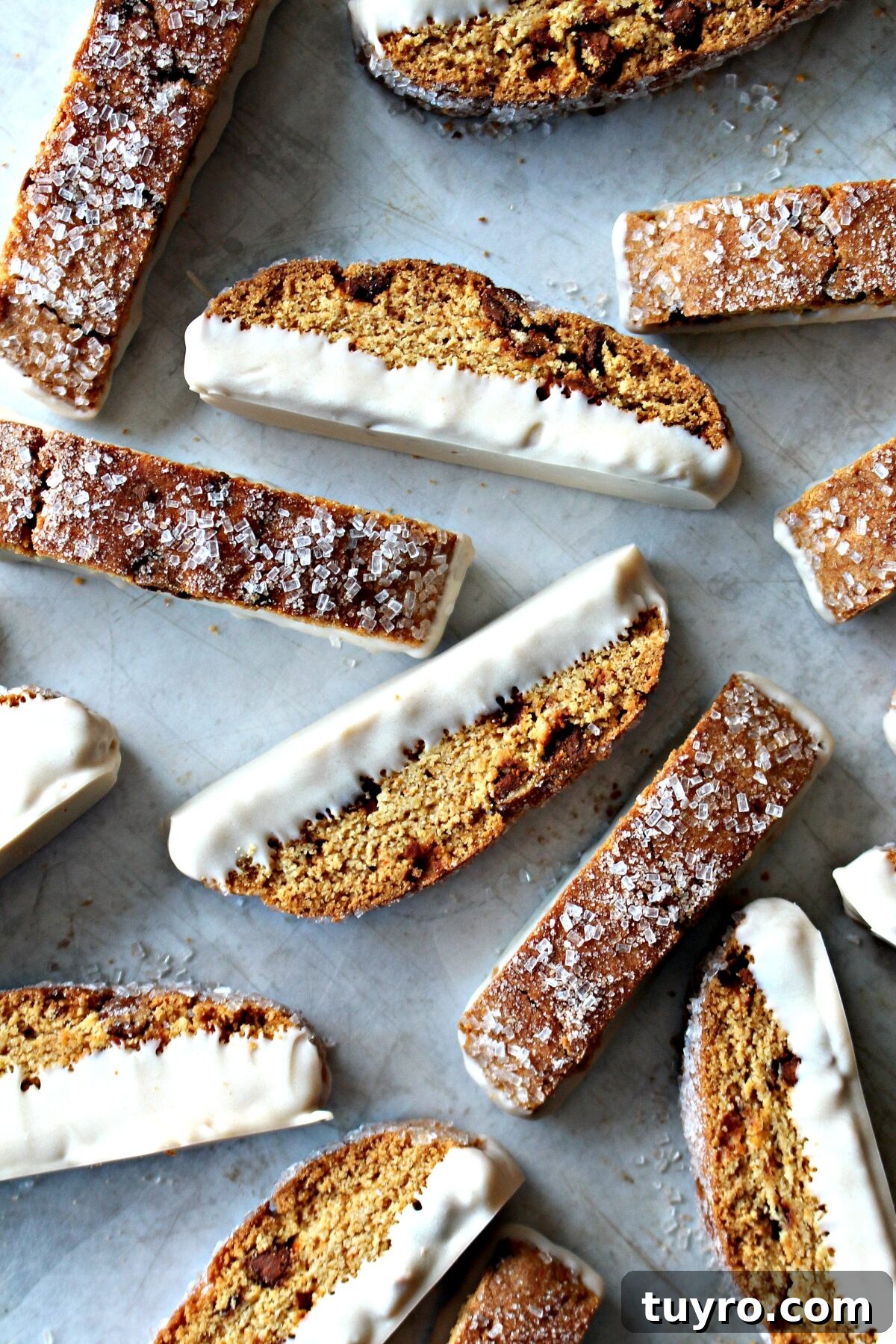 Cinnamon Chip Biscotti Recipe: Crispy Twice-Baked Cookies 2 Cinnamon Chip Biscotti with sparkling sugar on top, dipped in cinnamon white chocolate on the bottom.
