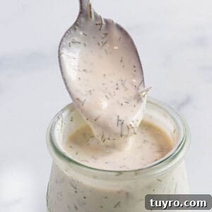 Creamy Lemon Dill Sauce Recipe for Fish and Salmon 9 A small weck jar with a creamy sauce with a spoon scooping some out.