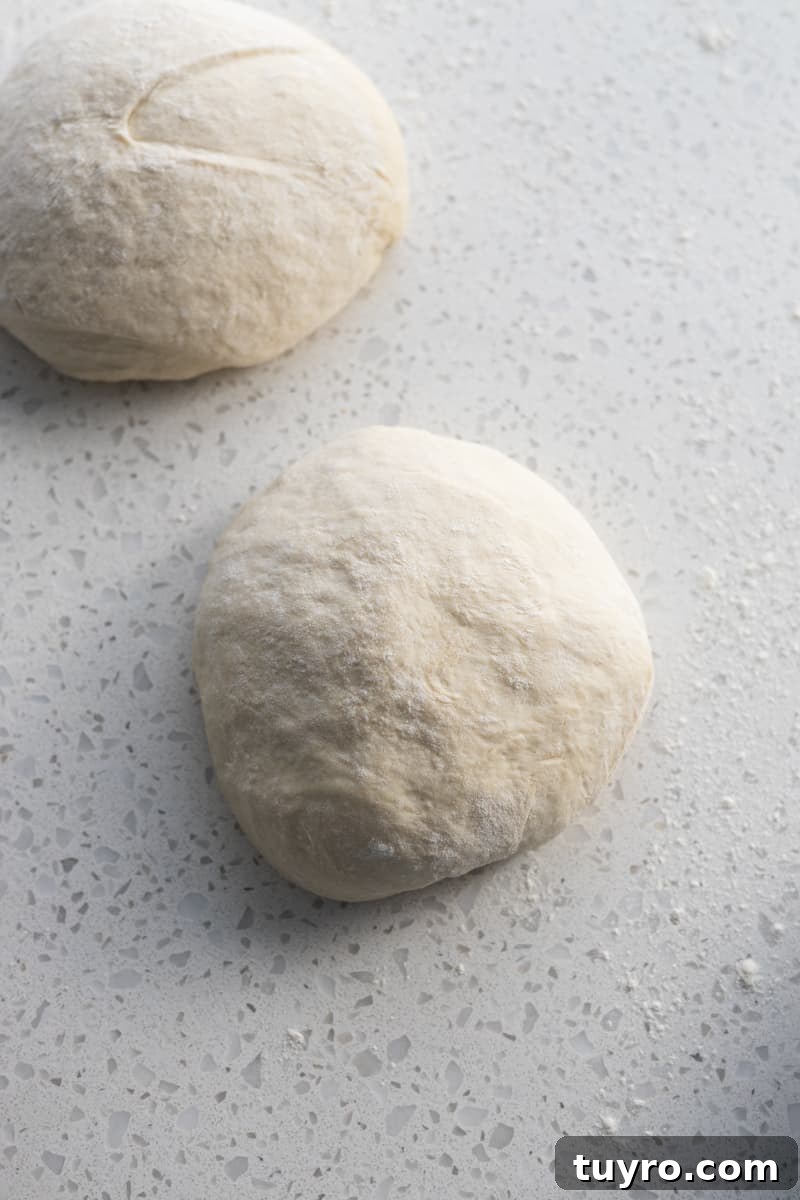 Sourdough discard pizza dough divided into two rounds.