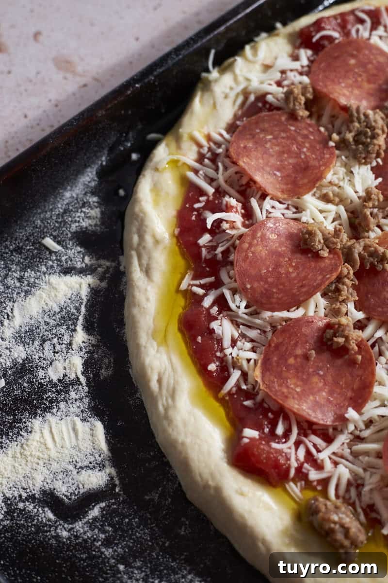 An overhead view of Sourdough Discard Pizza Dough with thick crust before baking.