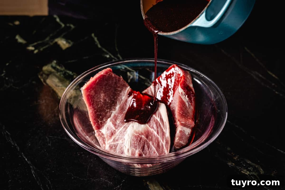 Authentic Cantonese Char Siu Pork Recipe: Smoky Oven-Roasted BBQ 5 Sauce pouring from a pot into a glass bowl of raw pork.