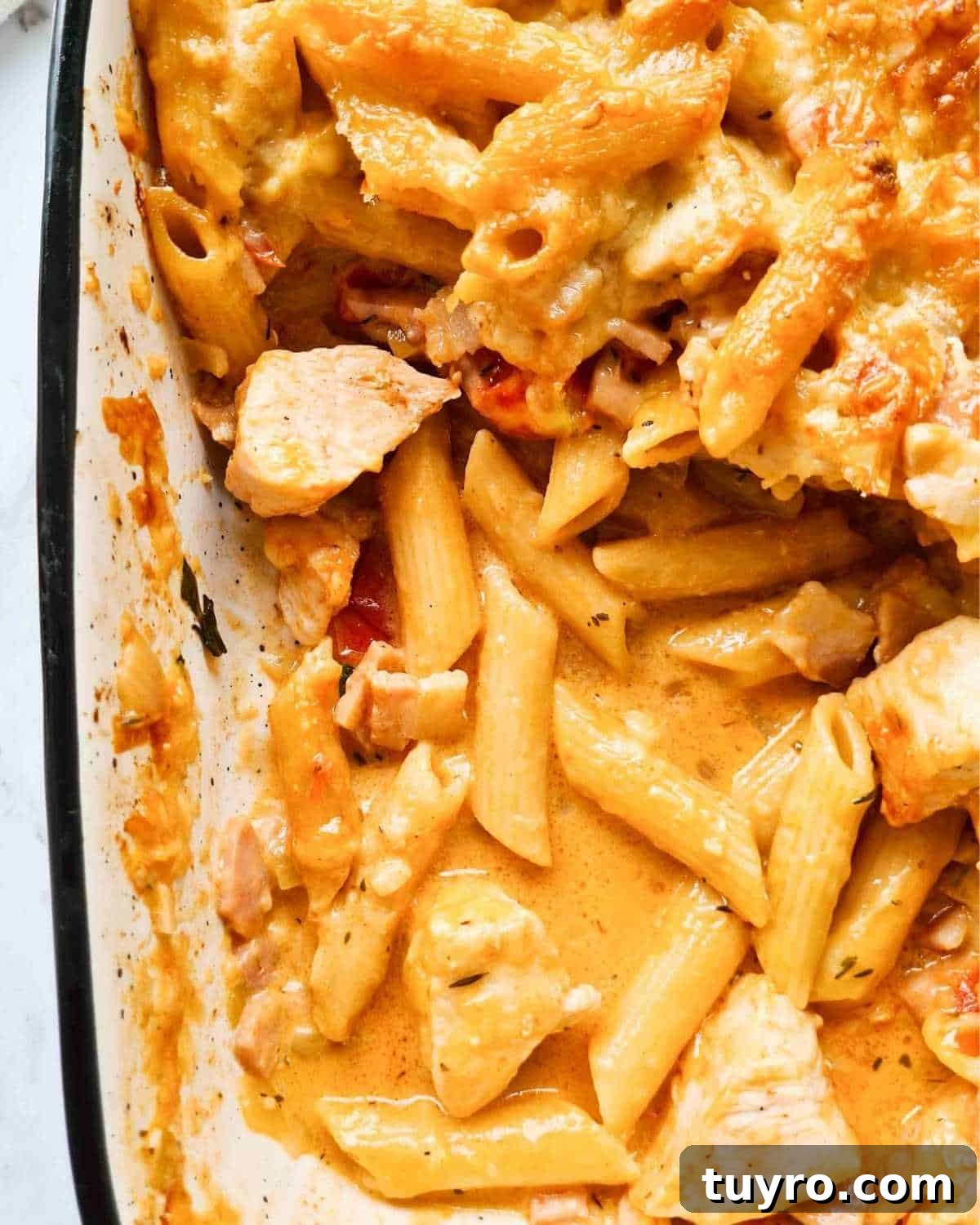 Creamy Chicken & Bacon Pasta Bake Recipe for Weeknight Dinners 10 A corner of a pasta bake tray with the top layer scooped out showing the creamy sauce
