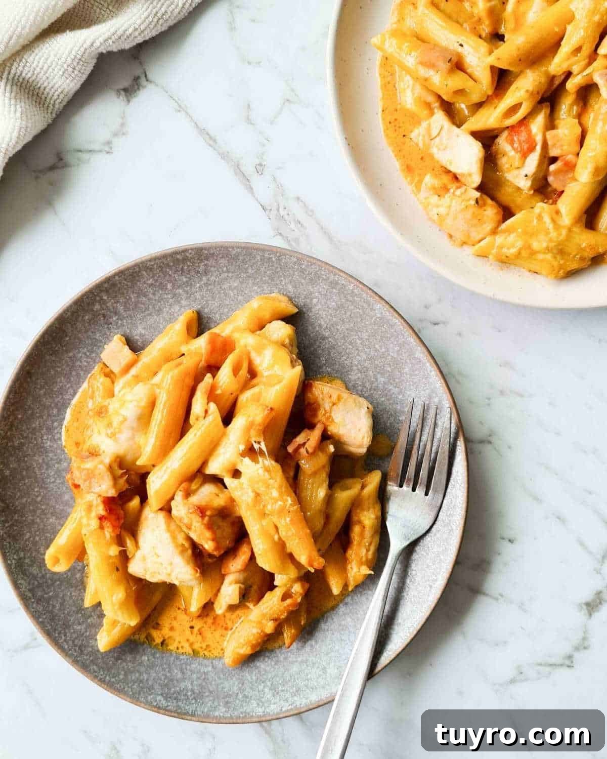 Creamy Chicken & Bacon Pasta Bake Recipe for Weeknight Dinners 4 Two plates of creamy chicken and bacon pasta, one plate with a fork
