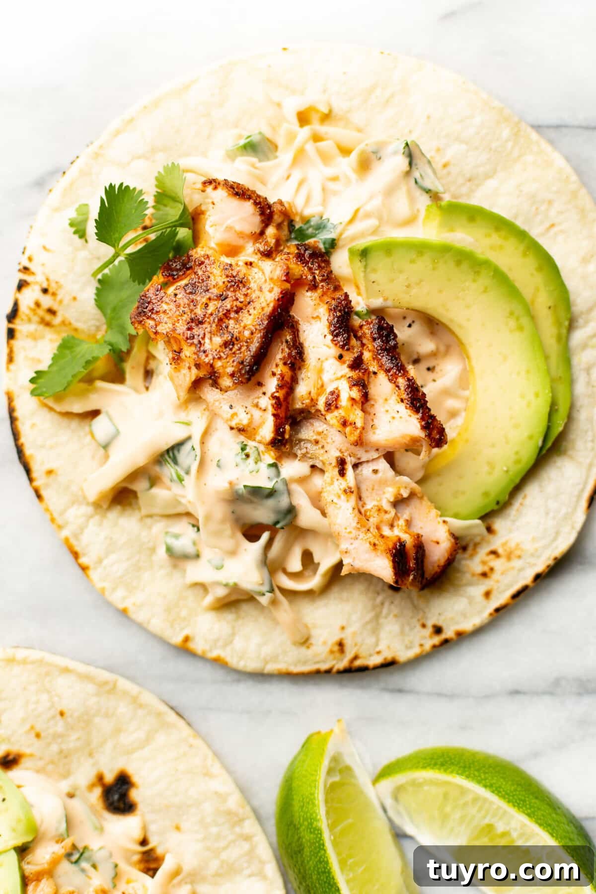 Grilled Salmon Tacos with Avocado Lime Crema 2 salmon tacos with lime wedges
