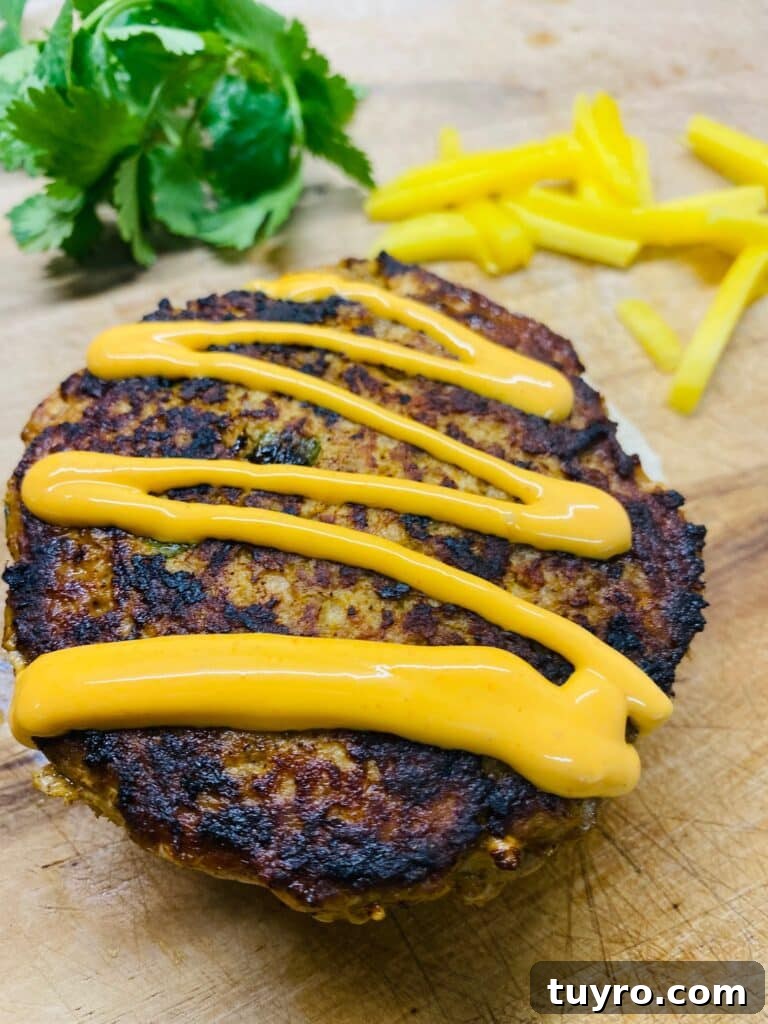 adding toppings to the Blackstone Caribbean Jerk Salmon Burgers