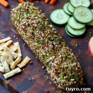 Festive Vegan Cheese Log Recipe for Holiday Parties 4 holiday cheese log on a party platter with veggies, chips, pita, and apple slices